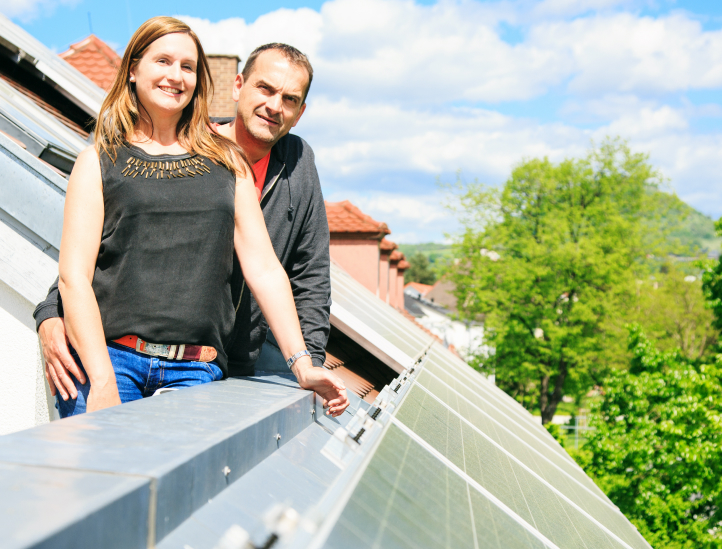 couple standing on a roof with solar panels